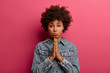 © WHstudio Leushin N - Innocent girl needs help, has miserable hopeful face expression, purses lower lip and pressed palms together, begs or pleads for favor, wears denim jacket, asks to lend money, has imploring gaze