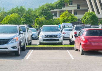 Wall Mural - Car parked in asphalt parking lot and one empty space parking  in nature with trees and mountain background