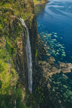 Mealt Waterfall With Kilt Rock On The Beautiful Scottish Isle Of Skye. Big Waterfall On A Sunny Scottish Day With Deep Blue Sea In The Background.