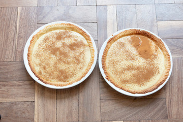 A close up view of two milk tarts in white bowls ready to eat