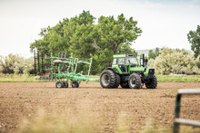 Farmer Driving Tractor Across Plowed Field. Bridger, Montana, USA