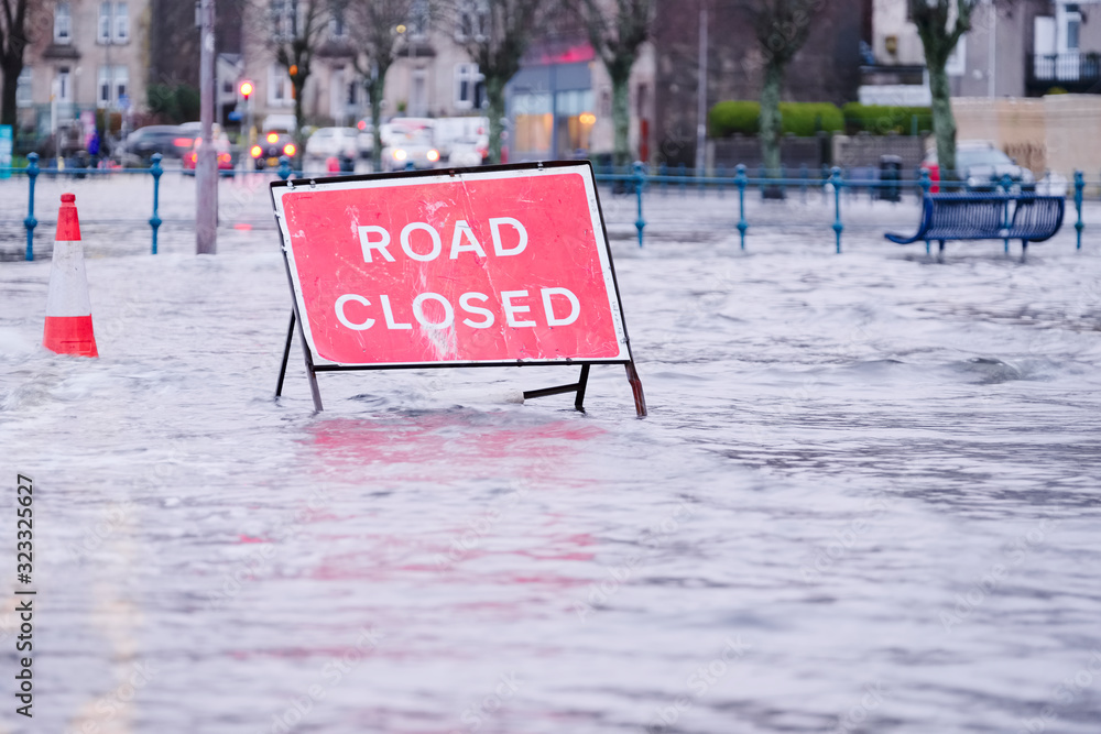 Road flood closed sign under deep water during bad extreme heavy rain storm weather in UK - obrazy, fototapety, plakaty 