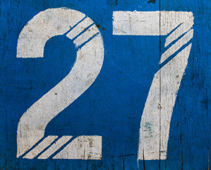 27. Weathered Old Painted Number On A Blue Wooden Surface.