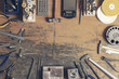 Top view of different goldsmiths tools on the jewelry workplace. Desktop for craft jewelry making with professional tools. Aerial view of tools over rustic wooden background. Poster design.