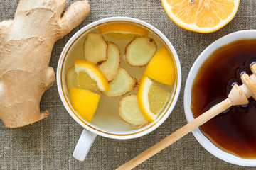 Canvas Print - A cup of tea with ginger and lemon on a textile background