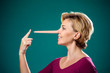 Woman touching her long nose because of lie . People,lifestyle and emotions concept