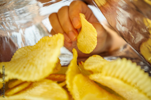 Fotografía Hand hold potato chips inside snack foil bag