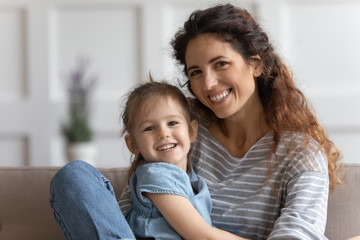 Wall Mural - Little preschool kid girl embracing smiling mommy.