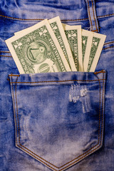 American one dollar banknotes in a pocket of blue jeans