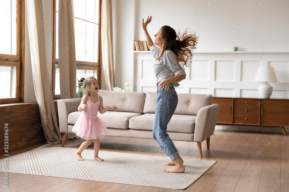 Crazy energetic family of two dancing in living room. - obrazy, fototapety, plakaty 