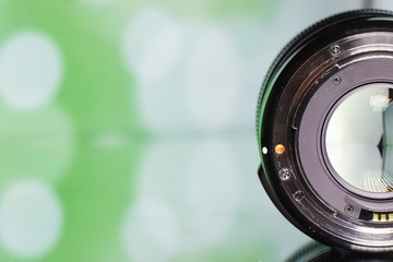 Equipment videographer and photographer. Lenses on the table against the background of bright lamps. Glare and bokeh in reflection of camera glass.