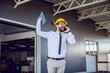 © Dusan Petkovic - Overjoyed bearded Caucasian CEO with helmet on head standing in front of printing shop and talking on the smart phone. Customer is satisfied.