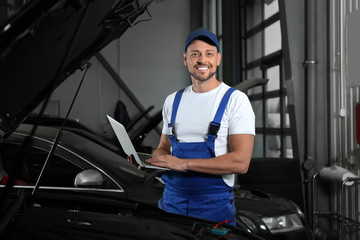 Wall Mural - Mechanic with laptop doing car diagnostic at automobile repair shop