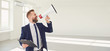 © Studio Romantic - Male real estate agent shioting in megaphone smiling in white real estate room apartment home