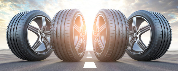 Wall Mural - Four car wheel oln the highway with sky background.  Change a tires.