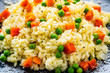 Risotto with carrot and grean peas on wooden background
