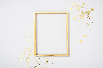 Gold frame with gold stars on white background. Flat lay, top view, copy space