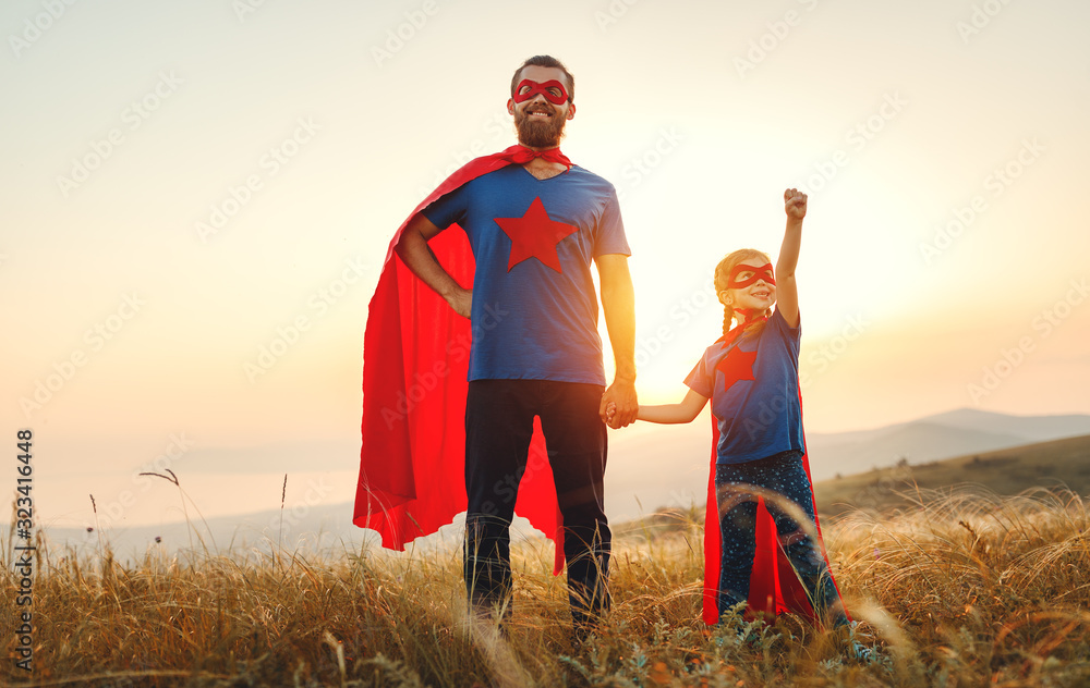 concept of father's day. dad and child daughter in hero superhero costume at sunset  . - obrazy, fototapety, plakaty 