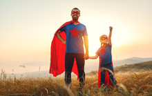 Concept Of Father's Day. Dad And Child Daughter In Hero Superhero Costume At Sunset  .