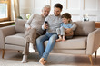 © fizkes - Joyful intergenerational male family taking selfie at home.