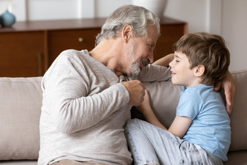 Wall Mural - Pleasant middle aged man having sincere trustful conversation with grandchild.