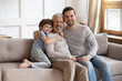 © fizkes - Portrait of smiling joyful multigenerational male family resting on couch.