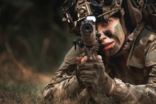 Close Up Of Woman Soldier Holding Gun Laying On The Ground