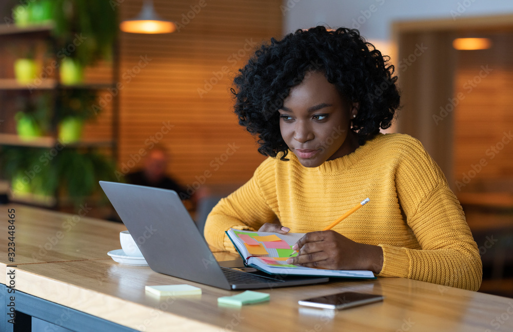 Concentrated black girl browsing job opportunities on laptop - obrazy, fototapety, plakaty 