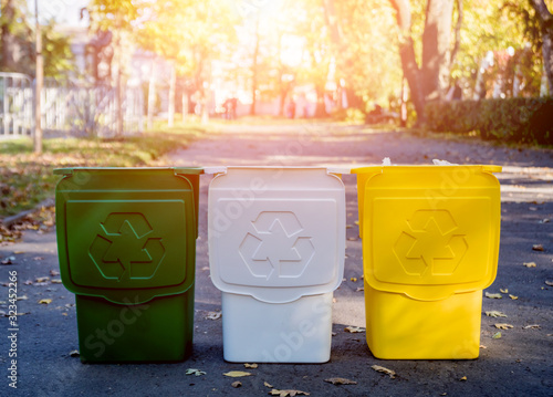 Three trash containers in different color, for sorted waste.