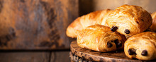 Freshly Baked Sweet Buns Puff Pastry With Chocolate And Croissants On Old Wooden Background. Breakfast Or Brunch Concept With Copy Space, Banner.