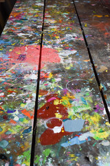 Wall Mural - Artists workshop or studio bench covered with splattered paint built up in authentic texture on painted surface