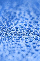 Drops on the skin. Artificial leather. Close-up of water drops. Abstract blue wet texture with drops on the surface. Realistic clean water drops. Classic blue