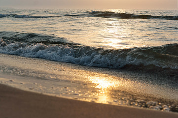 Sunset over the sea. Reflection of sunlight in the sea waves. The sky in the sunset rays.