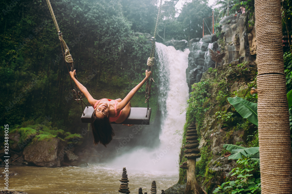 Beautiful girl having fun at the waterfalls in Bali. Concept about wanderlust traveling and wilderness culture - obrazy, fototapety, plakaty 