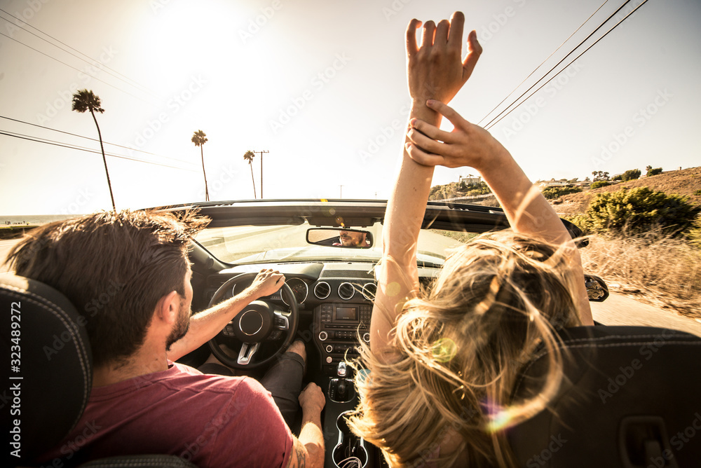 Couple driving on a convertible car - obrazy, fototapety, plakaty 
