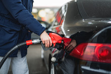 Close-up Of A Man Pumping Gasoline Into A Car At A Gas Station.