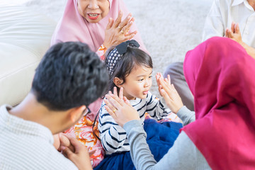 Girl clapping hands with her muslim mother happily