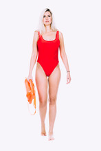 Pretty Young Woman Lifeguard In Red Sexy Swimsuit With Lifeguard Rescue Can Floating Buoy Tube On The White Background. Concept Woman In Swimsuite. Toned Image