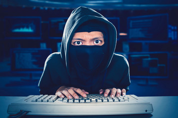 man typing fiercely and cautiously in system room