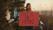 © koshkin_stock - Unhappy woman activist holding encouraging red poster This is our future standing at landfill site with garbage nature environmental community earth eco environment outdoor recycle trash waste