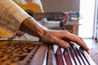 © Valmedia - Closeup of senior hands playing indian classical sacred kirtan music for silence and peace using harmonium with woman playing classical guitar