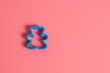 Blue plastic cookie cutter for making cookies in the shape of a teddy bear on a pink background. Culinary concept. Flat lay with copyspace.