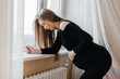 © Andrii - Severe pain in a pregnant woman standing near the window. Pregnancy