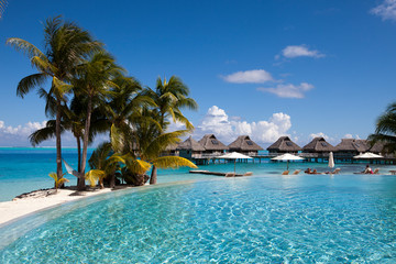 Wall Mural - French Polynesia. Over water bungalows, sandy beach with palm trees and pool, Bora Bora..