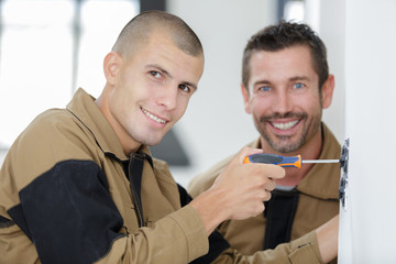 two mans assembling furniture on floor of apartment