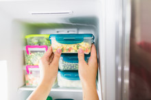 Woman Taking Container With Frozen Mixed Vegetables From Freezer.