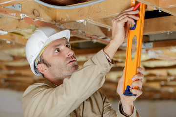 builder in uniform holding a level