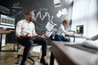 © Svitlana - There is no I in Team. Three traders working in the office. Employee throwing papers out of anger. Colleagues are looking tired and desperate.