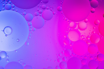 Oil drops on water surface color abstract background. blue and pink circles