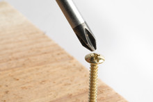 A Macro Selective Focus Lose Up Of A Phillips Cross Style Screwdriver And Phillips Cross Style Wood Screw Isolated On White